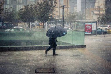 Tel Aviv, İsrail, 29 Aralık 2025. Yayalar şemsiyelerle yağmurda yürür Orta Doğu 'nun en modern şehirlerinden biri olan Tel Aviv sokaklarında..