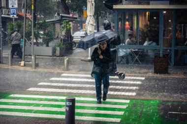 Tel Aviv, İsrail, 29 Aralık 2025. Yayalar şemsiyelerle yağmurda yürür Orta Doğu 'nun en modern şehirlerinden biri olan Tel Aviv sokaklarında..