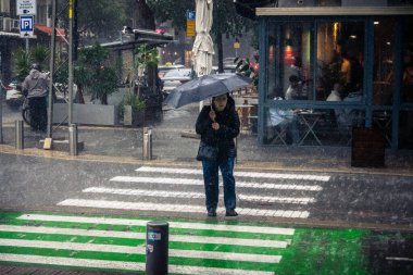 Tel Aviv, İsrail, 29 Aralık 2025. Yayalar şemsiyelerle yağmurda yürür Orta Doğu 'nun en modern şehirlerinden biri olan Tel Aviv sokaklarında..