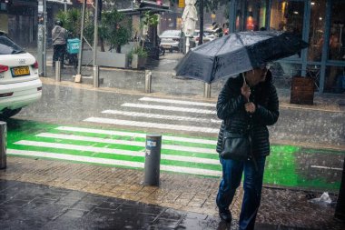 Tel Aviv, İsrail, 29 Aralık 2025. Yayalar şemsiyelerle yağmurda yürür Orta Doğu 'nun en modern şehirlerinden biri olan Tel Aviv sokaklarında..
