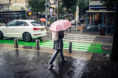 Tel Aviv, İsrail, 29 Aralık 2025. Yayalar şemsiyelerle yağmurda yürür Orta Doğu 'nun en modern şehirlerinden biri olan Tel Aviv sokaklarında..