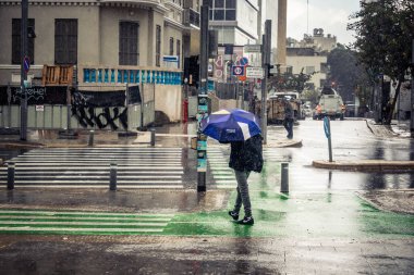Tel Aviv, İsrail, 29 Aralık 2025. Yayalar şemsiyelerle yağmurda yürür Orta Doğu 'nun en modern şehirlerinden biri olan Tel Aviv sokaklarında..