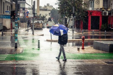 Tel Aviv, İsrail, 29 Aralık 2025. Yayalar şemsiyelerle yağmurda yürür Orta Doğu 'nun en modern şehirlerinden biri olan Tel Aviv sokaklarında..