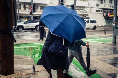 Tel Aviv, İsrail, 29 Aralık 2025. Yayalar şemsiyelerle yağmurda yürür Orta Doğu 'nun en modern şehirlerinden biri olan Tel Aviv sokaklarında..