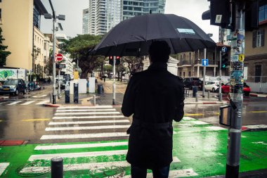 Tel Aviv, İsrail, 29 Aralık 2025. Yayalar şemsiyelerle yağmurda yürür Orta Doğu 'nun en modern şehirlerinden biri olan Tel Aviv sokaklarında..