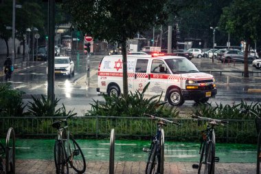 Tel Aviv, İsrail, 29 Aralık 2025. Magen David Adom (MDA) ambulansı Tel Aviv, İsrail sokaklarında acil durum ışıklarıyla yol alıyor. Kentsel acil servis sahnesi.