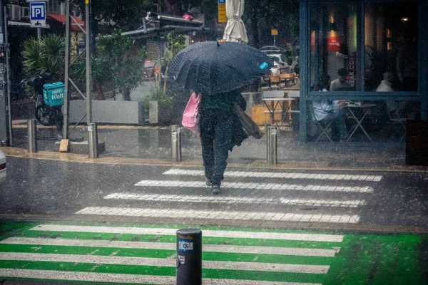 Tel Aviv, İsrail, 29 Aralık 2025. Yayalar şemsiyelerle yağmurda yürür Orta Doğu 'nun en modern şehirlerinden biri olan Tel Aviv sokaklarında..