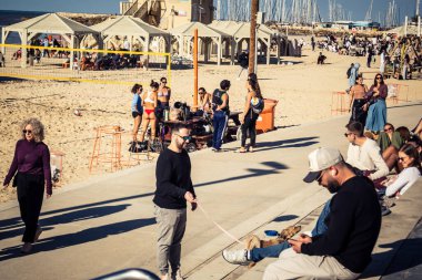 Tel Aviv, İsrail, 3 Ocak 2026 plaja bakan basamaklarda oturan insanlar bir anlık sakinliğin tadını çıkarıyorlar. Bölgesel çatışmalarla işaretlenmiş bir şehirde, bu toplantılar dinginliğe duyulan ihtiyacı yansıtıyor.