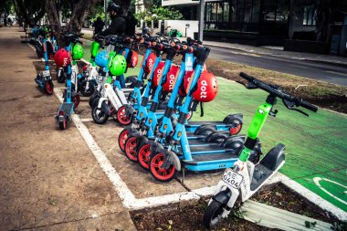 Tel Aviv, İsrail, 14 Ocak 2026 Rothschild Bulvarı boyunca elektrikli scooterlar park etti. Tel Aviv 'de ağaçlarla kaplı, canlı bir merkez cadde. Modern şehir yaşam tarzını yansıtıyor..