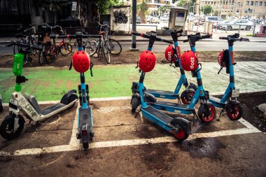 Tel Aviv, İsrail, 14 Ocak 2026 Rothschild Bulvarı boyunca elektrikli scooterlar park etti. Tel Aviv 'de ağaçlarla kaplı, canlı bir merkez cadde. Modern şehir yaşam tarzını yansıtıyor..