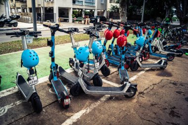 Tel Aviv, İsrail, 14 Ocak 2026 Rothschild Bulvarı boyunca elektrikli scooterlar park etti. Tel Aviv 'de ağaçlarla kaplı, canlı bir merkez cadde. Modern şehir yaşam tarzını yansıtıyor..