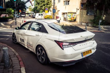 Tel Aviv, İsrail, 14 Ocak 2026 Taksiler Rothschild Bulvarı boyunca hareketli, ağaçlarla kaplı bir merkez caddede ilerliyorlar. Şehir hareketliliğini ve akışını sürdüren modern şehir yaşam tarzını yansıtıyorlar..
