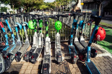 Tel Aviv, İsrail, 14 Ocak 2026 Rothschild Bulvarı boyunca elektrikli scooterlar park etti. Tel Aviv 'de ağaçlarla kaplı, canlı bir merkez cadde. Modern şehir yaşam tarzını yansıtıyor..