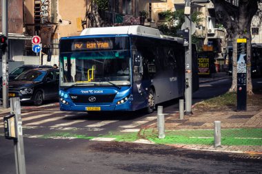 Tel Aviv, İsrail, 14 Ocak 2026 Autobus Rothschild Bulvarı boyunca hareketli, ağaçlarla çevrili bir merkez caddede ilerler. Şehir hareketliliğini ve akışını koruyan modern şehir yaşam tarzını yansıtır..
