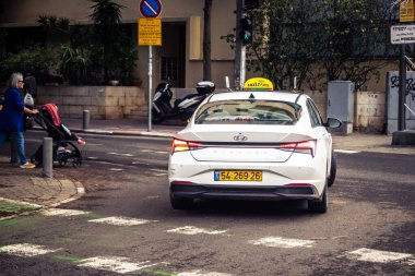 Tel Aviv, İsrail, 14 Ocak 2026 Taksiler Rothschild Bulvarı boyunca hareketli, ağaçlarla kaplı bir merkez caddede ilerliyorlar. Şehir hareketliliğini ve akışını sürdüren modern şehir yaşam tarzını yansıtıyorlar..