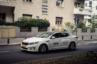Tel Aviv, İsrail, 14 Ocak 2026 Taksiler Rothschild Bulvarı boyunca hareketli, ağaçlarla kaplı bir merkez caddede ilerliyorlar. Şehir hareketliliğini ve akışını sürdüren modern şehir yaşam tarzını yansıtıyorlar..