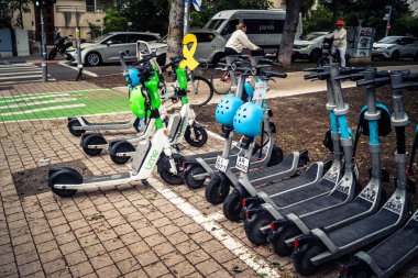 Tel Aviv, İsrail, 14 Ocak 2026 Rothschild Bulvarı boyunca elektrikli scooterlar park etti. Tel Aviv 'de ağaçlarla kaplı, canlı bir merkez cadde. Modern şehir yaşam tarzını yansıtıyor..