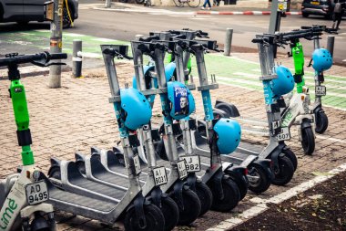 Tel Aviv, İsrail, 14 Ocak 2026 Rothschild Bulvarı boyunca elektrikli scooterlar park etti. Tel Aviv 'de ağaçlarla kaplı, canlı bir merkez cadde. Modern şehir yaşam tarzını yansıtıyor..