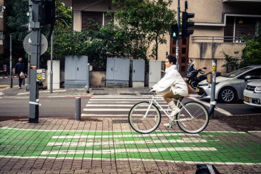 Tel Aviv, İsrail, 14 Ocak 2026. Bisikletçiler, Tel Aviv 'de Rothschild Bulvarı boyunca, modern şehir yaşam tarzını yansıtan, ağaçlarla çevrili, canlı bir merkez caddeye gidiyorlar..