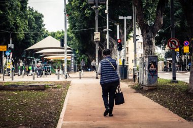 Tel Aviv, İsrail, 14 Ocak 2026. Tel Aviv 'deki Rothschild Bulvarı' ndaki insanlar, şehrin modern kentsel yaşam tarzını yansıtan canlı, ağaçlarla kaplı bir merkez cadde..