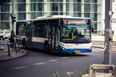 Tel Aviv, İsrail, 14 Ocak 2026 Autobus Rothschild Bulvarı boyunca hareketli, ağaçlarla çevrili bir merkez caddede ilerler. Şehir hareketliliğini ve akışını koruyan modern şehir yaşam tarzını yansıtır..