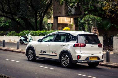 Tel Aviv, İsrail, 14 Ocak 2026 Taksiler Rothschild Bulvarı boyunca hareketli, ağaçlarla kaplı bir merkez caddede ilerliyorlar. Şehir hareketliliğini ve akışını sürdüren modern şehir yaşam tarzını yansıtıyorlar..