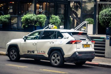 Tel Aviv, İsrail, 14 Ocak 2026 Taksiler Rothschild Bulvarı boyunca hareketli, ağaçlarla kaplı bir merkez caddede ilerliyorlar. Şehir hareketliliğini ve akışını sürdüren modern şehir yaşam tarzını yansıtıyorlar..