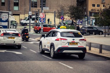 Tel Aviv, İsrail, 14 Ocak 2026 Taksiler Rothschild Bulvarı boyunca hareketli, ağaçlarla kaplı bir merkez caddede ilerliyorlar. Şehir hareketliliğini ve akışını sürdüren modern şehir yaşam tarzını yansıtıyorlar..