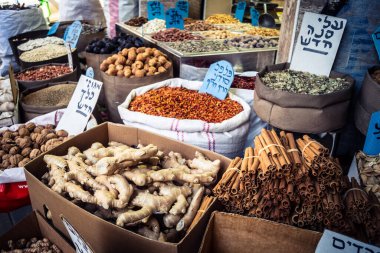 Tel Aviv, İsrail, 16 Ocak 2026 ünlü Levinsky Pazarı 'nın kalbinde canlı bir günlük sahne. İran baharatları, kurutulmuş meyveler ve yerel spesiyalitelerle dolu renkli tezgahlar..