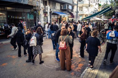 Tel Aviv, İsrail, 16 Ocak 2026 Ünlü Levinsky Pazarı 'nın merkezinde canlı bir günlük sahne. İran baharatları, kurutulmuş meyveler ve yerel spesiyalitelerle dolu renkli tezgahlar..