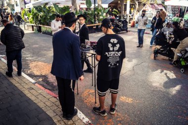 Tel Aviv, İsrail, 16 Ocak 2026 Ünlü Levinsky Pazarı 'nın merkezinde canlı bir günlük sahne. İran baharatları, kurutulmuş meyveler ve yerel spesiyalitelerle dolu renkli tezgahlar..