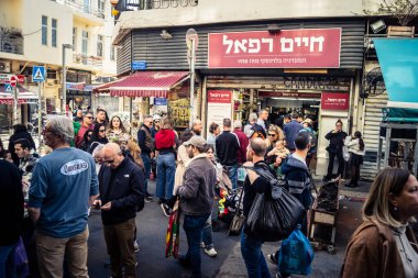 Tel Aviv, İsrail, 16 Ocak 2026 Ünlü Levinsky Pazarı 'nın merkezinde canlı bir günlük sahne. İran baharatları, kurutulmuş meyveler ve yerel spesiyalitelerle dolu renkli tezgahlar..