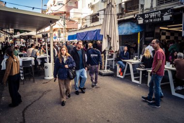 Tel Aviv, İsrail, 16 Ocak 2026 Ünlü Levinsky Pazarı 'nın merkezinde canlı bir günlük sahne. İran baharatları, kurutulmuş meyveler ve yerel spesiyalitelerle dolu renkli tezgahlar..