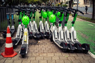 Tel Aviv, İsrail, 21 Ocak 2026 Rothschild Bulvarı boyunca elektrikli scooterlar park etti. Tel Aviv 'de ağaçlarla kaplı, canlı bir merkez cadde. Modern şehir yaşam tarzını yansıtıyor..