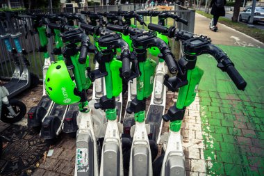 Tel Aviv, İsrail, 21 Ocak 2026 Rothschild Bulvarı boyunca elektrikli scooterlar park etti. Tel Aviv 'de ağaçlarla kaplı, canlı bir merkez cadde. Modern şehir yaşam tarzını yansıtıyor..