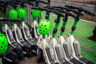 Tel Aviv, İsrail, 21 Ocak 2026 Rothschild Bulvarı boyunca elektrikli scooterlar park etti. Tel Aviv 'de ağaçlarla kaplı, canlı bir merkez cadde. Modern şehir yaşam tarzını yansıtıyor..