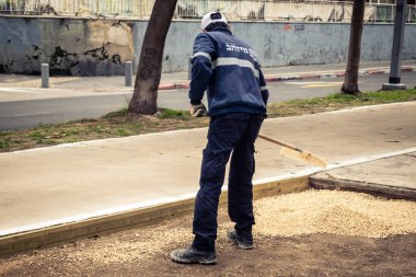 Tel Aviv, İsrail, 21 Ocak 2026 Tel Aviv Şehir Parkları Departmanı 'nın bir çalışanı Rothschild Bulvarı' na dekoratif çakıl yayıyor..