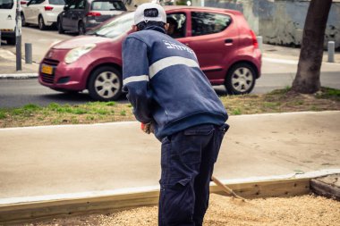 Tel Aviv, İsrail, 21 Ocak 2026 Tel Aviv Şehir Parkları Departmanı 'nın bir çalışanı Rothschild Bulvarı' na dekoratif çakıl yayıyor..