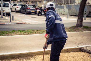 Tel Aviv, İsrail, 21 Ocak 2026 Tel Aviv Şehir Parkları Departmanı 'nın bir çalışanı Rothschild Bulvarı' na dekoratif çakıl yayıyor..