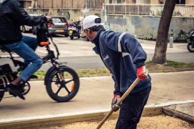 Tel Aviv, İsrail, 21 Ocak 2026 Tel Aviv Şehir Parkları Departmanı 'nın bir çalışanı Rothschild Bulvarı' na dekoratif çakıl yayıyor..