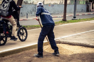 Tel Aviv, İsrail, 21 Ocak 2026 Tel Aviv Şehir Parkları Departmanı 'nın bir çalışanı Rothschild Bulvarı' na dekoratif çakıl yayıyor..