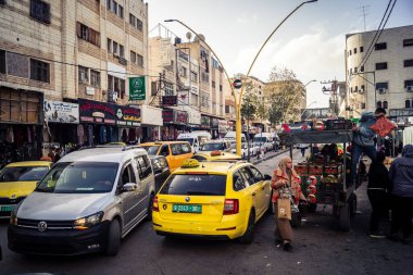 Hebron, Batı Şeria, 27 Ocak 2026 Eski Şehir girişine yakın işlek bir caddenin genel manzarası. Sarı taksiler ve yerel pazarlar, Batı Şeria 'daki günlük hareketlilik ve ekonomik yaşamı gösteriyor.