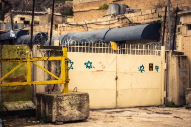 Hebron, Batı Şeria, 29 Ocak 2026 Dikenli tel ve mühürlü kapılar İsrail 'in El Halil' deki askeri işgalini zorunlu kılıyor. H2 sektöründeki güvenlik bariyerleri tarihi merkezi hayalet kasabaya çevirdi..