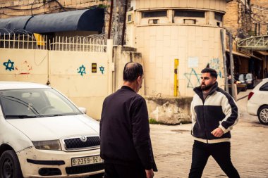 Hebron, Batı Şeria, 29 Ocak 2026 Filistinliler El Halil 'in girişindeki askeri kontrol noktasından geçtiler. Bölünmüş şehirde günlük gözetim ve kısıtlı hareket.