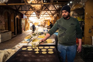 Hebron, Batı Şeria, 29 Ocak 2026 Filistinli sanatçılar Eski El Halil 'de geleneksel Katayef krepleri pişiriyorlar. Bölünmüş kentte kültürel mirasın ve günlük dayanıklılığın canlı bir sembolü..
