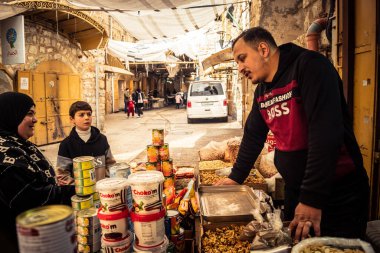 Hebron, Batı Şeria, 29 Ocak 2026 Filistinliler El Halil 'deki nadir bulunan bir mağazadan alışveriş yapıyorlar. Harabeler ve askeri kapanışlar arasında kırılgan bir yaşam ve hayatta kalma işareti..