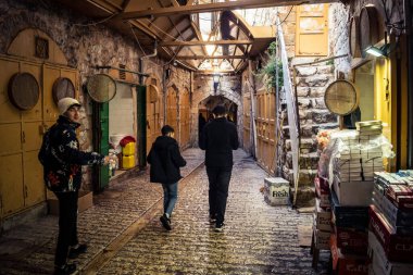 Hebron, Batı Şeria, 29 Ocak 2026 Filistinliler El Halil 'in ıssız sokaklarında gölge gibi yürüyorlar. Askeri işgalin ağırlığı altında izole edilmiş ve çürümüş bir sahne..