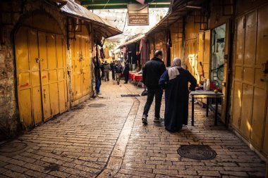 Hebron, Batı Şeria, 29 Ocak 2026 Filistinliler El Halil 'in ıssız sokaklarında gölge gibi yürüyorlar. Askeri işgalin ağırlığı altında izole edilmiş ve çürümüş bir sahne..
