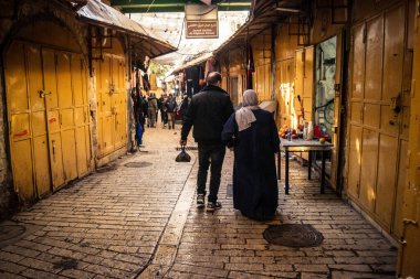 Hebron, Batı Şeria, 29 Ocak 2026 Filistinliler El Halil 'in ıssız sokaklarında gölge gibi yürüyorlar. Askeri işgalin ağırlığı altında izole edilmiş ve çürümüş bir sahne..