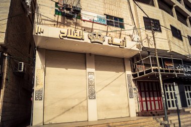 Hebron, Batı Şeria, 30 Ocak 2026 kapalı dükkan kepenkleri ve Hebron şehrinin caddesinde çift taraflı metal kapılar. Cuma günkü ticari kapanma sembolleri.